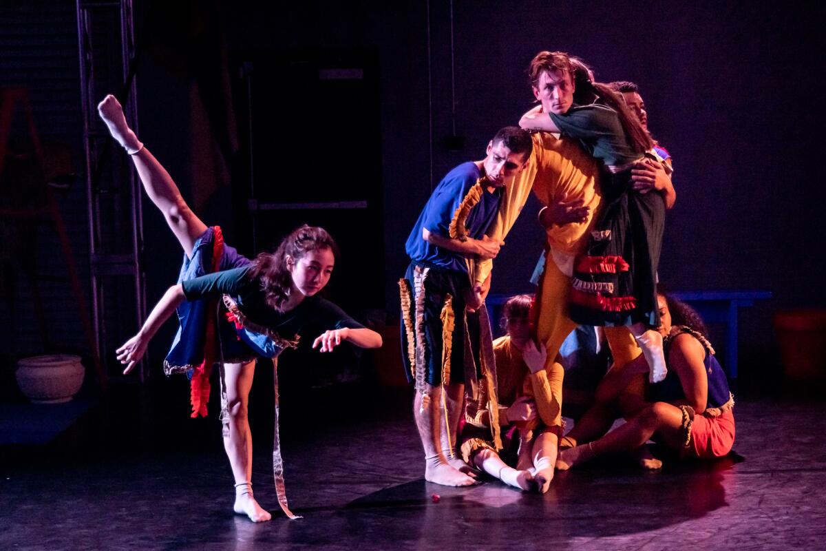 Dancers stretch and pose as part of a dance routine.