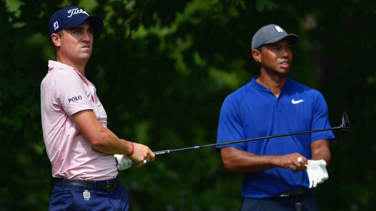 Justin Thomas plays a shot as Tiger Woods looks on during a practice round prior to the 2018 PGA Championship at Bellerive Country Club on Wednesday in St. Louis.