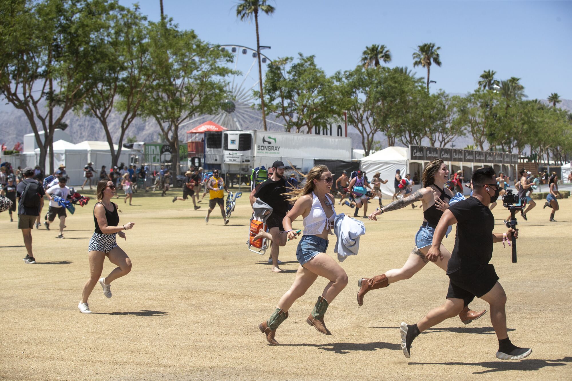 People run across a dirt field
