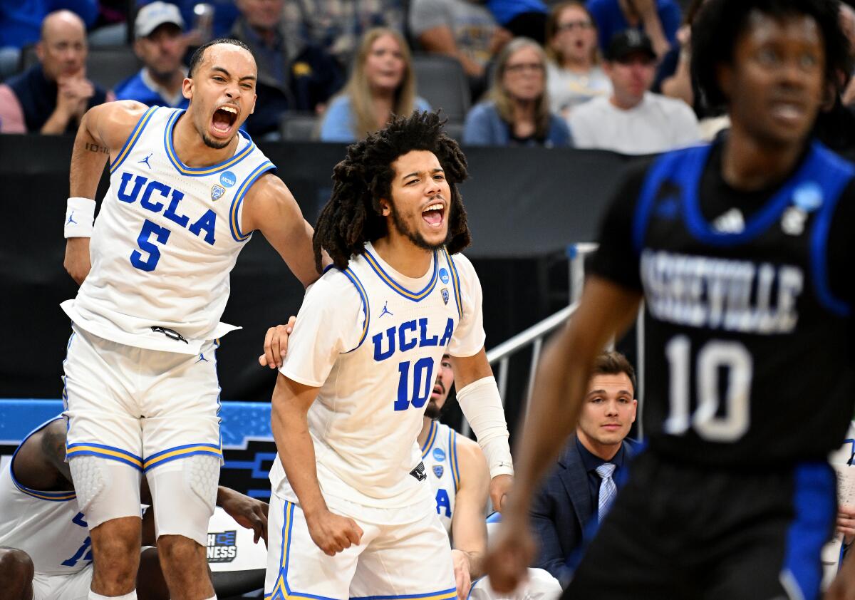 UCLA's Amari Bailey and Tyger Campbell celebrate on the bench against UNC Asheville.