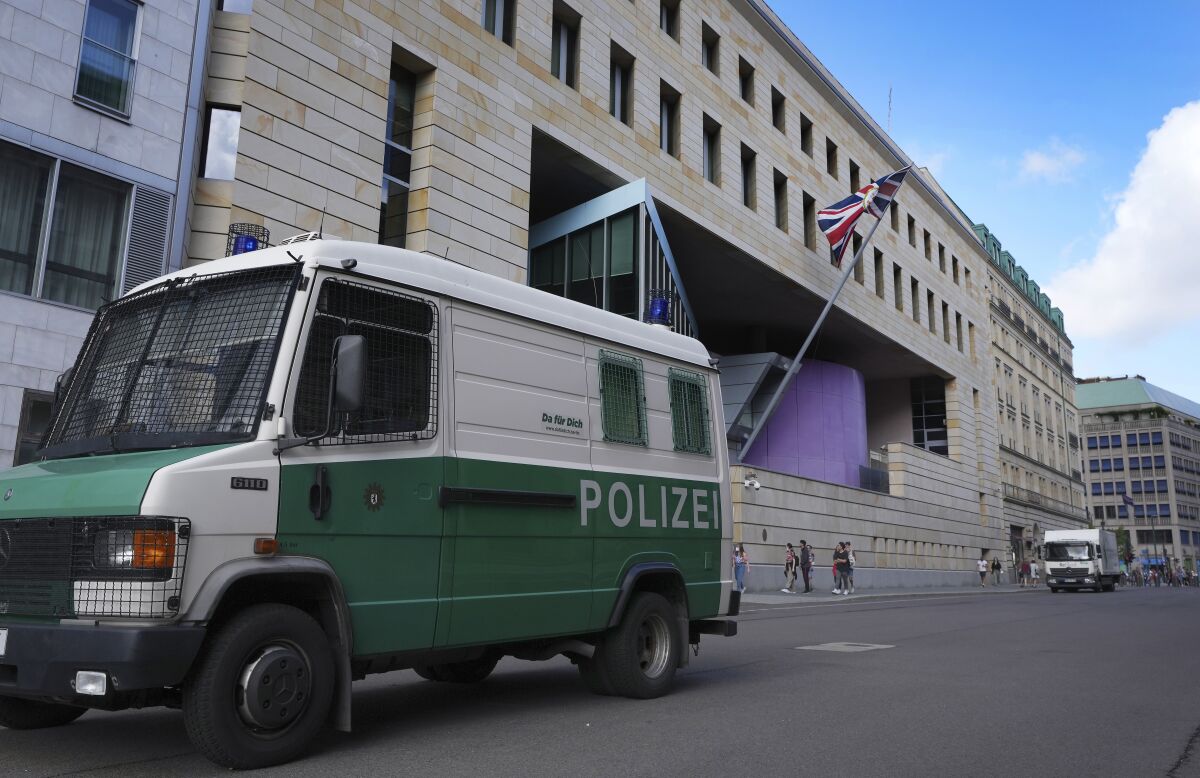 A police car is parked in front of the British embassy in Berlin, Germany, Wednesday, Aug. 11, 2021. German prosecutors say they have detained a British citizen who is accused of spying for Russia while working at the British Embassy in Berlin. (AP Photo/Michael Sohn)