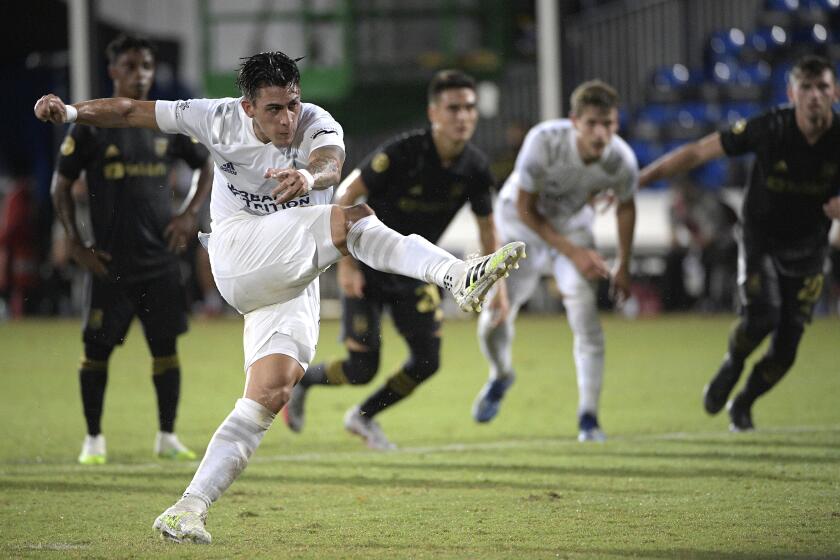 LA Galaxy forward Cristian Pavon follows through on a penalty kick during the first half of an MLS soccer match against the Los Angeles FC, Saturday, July 18, 2020, in Kissimmee, Fla. (AP Photo/Phelan M. Ebenhack)