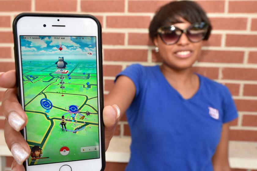 Keyanna Arnett poses with the Pokémon Go game on her cell phone at Augusta University in Augusta, Ga.