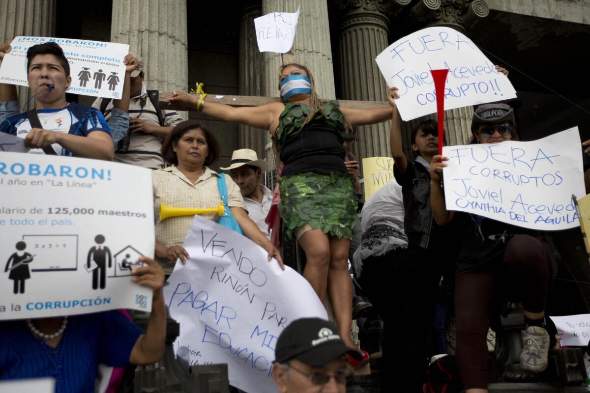 Una mujer crucificada con una bandera guatemalteca sobre su boca, en representación de cómo la corrupción mata a sus compatriotasl. (Foto AP/Moisés Castillo)