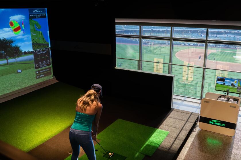 A woman uses an indoor golf simulator at the Milwaukee Brewers' American Family Field in Wisconsin.