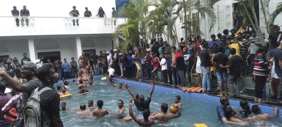 Anti government protesters swim in a swimmingpool of the Sri lankan president's official residence after storming into it in Colombo, Sri Lanka, Saturday, July 9, 2022. (AP Photo)