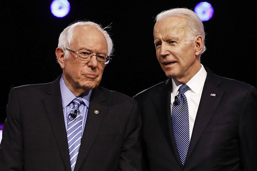 Bernie Sanders, left, and Joe Biden chat before a Democratic presidential debate in Charleston, S.C., on Feb. 25.