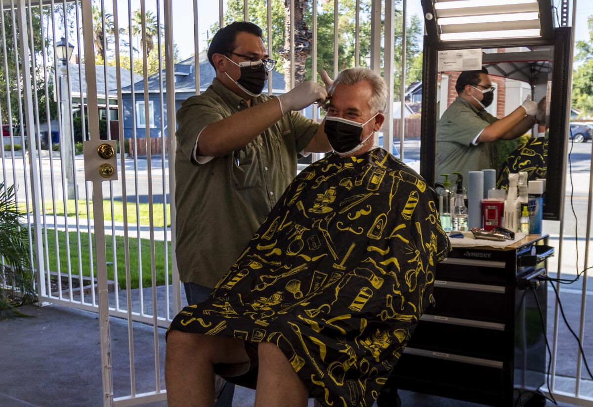 Obie Figueroa, owner of Obie's Barbershop & Shave in Riverside, cuts San Dimas resident Matt Nelson's hair Tuesday