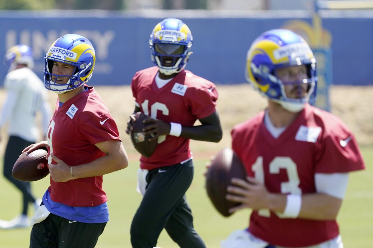 From left, Rams quarterbacks Matthew Stafford, Bryce Perkins and John Wolford work on a drill simultaneously. 