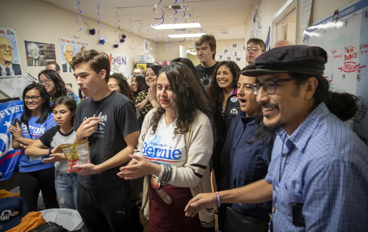 Joesé Hernandez, right, and activist Alicia Rojas, center, join Bernie Sanders campaign volunteers to celebrate Sanders' projected victory March 3 in California.