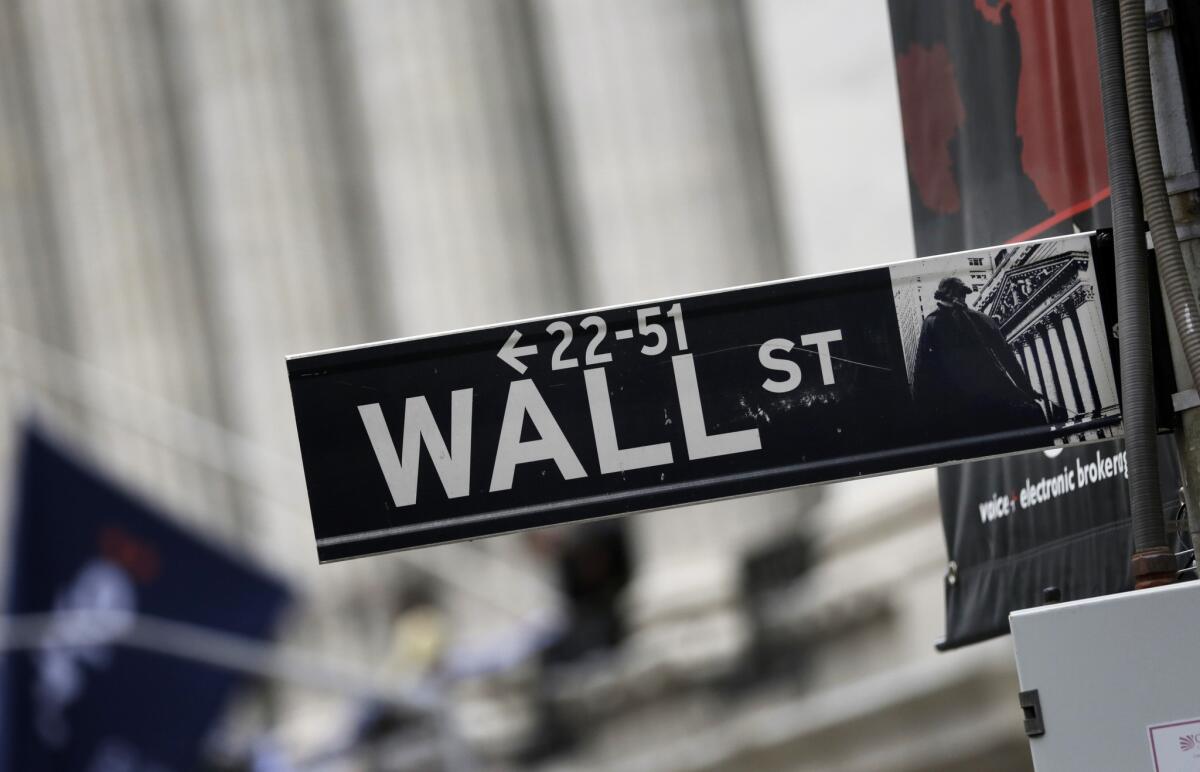 A Wall Street sign stands outside the New York Stock Exchange on Oct. 2, 2014.