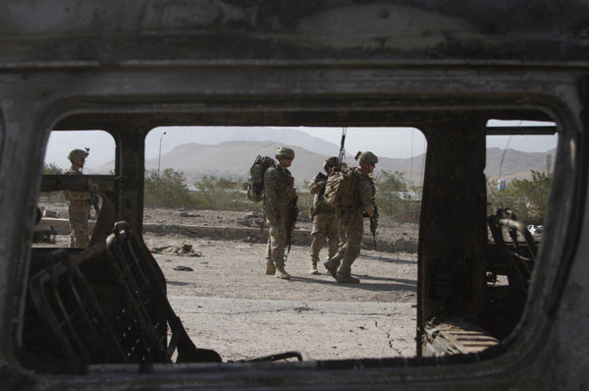 U.S. troops, part of the NATO-led International Security Assistance Force, investigate the site of a suicide attack in Wardak province, east of Kabul, Afghanistan, on Sunday.