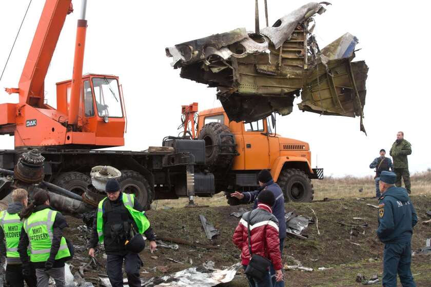 Workers remove the wreckage of Malaysia Airlines Flight 17 from separatist-held territory in eastern Ukraine, four months after it was shot down. All 298 people on the plane died.