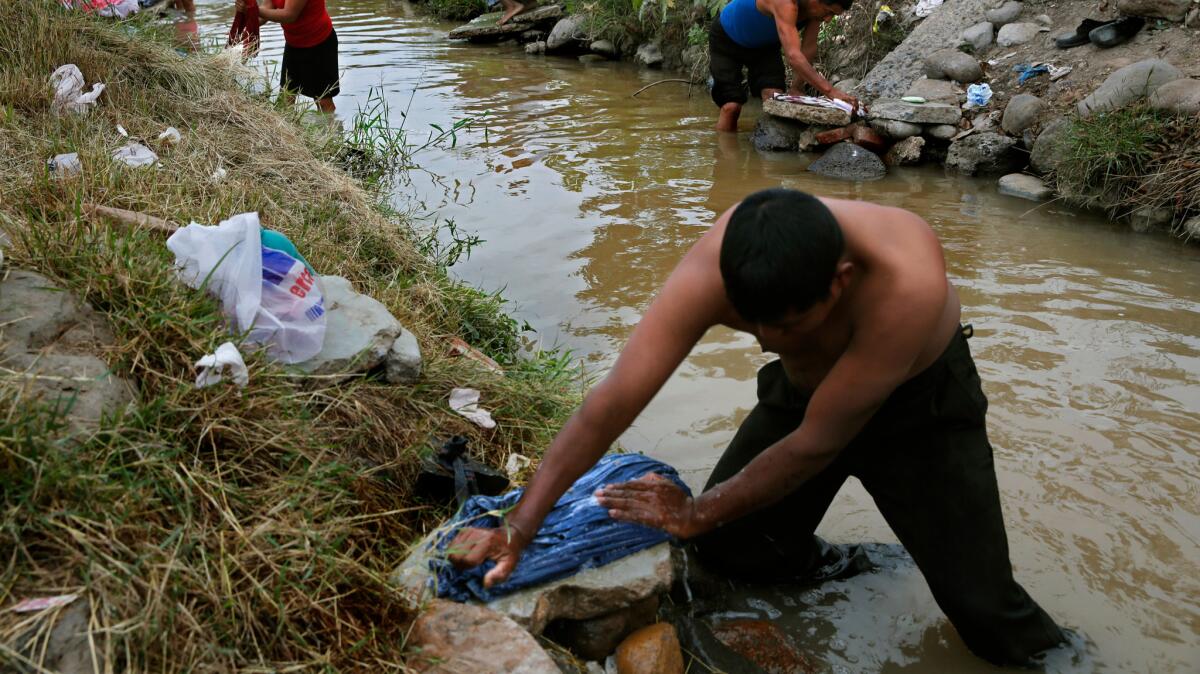 Farm laborer Luis Perez washes clothes after bathing in an irrigation canal outside Campo San Jose in the Mexican state of Sinaloa in 2013.