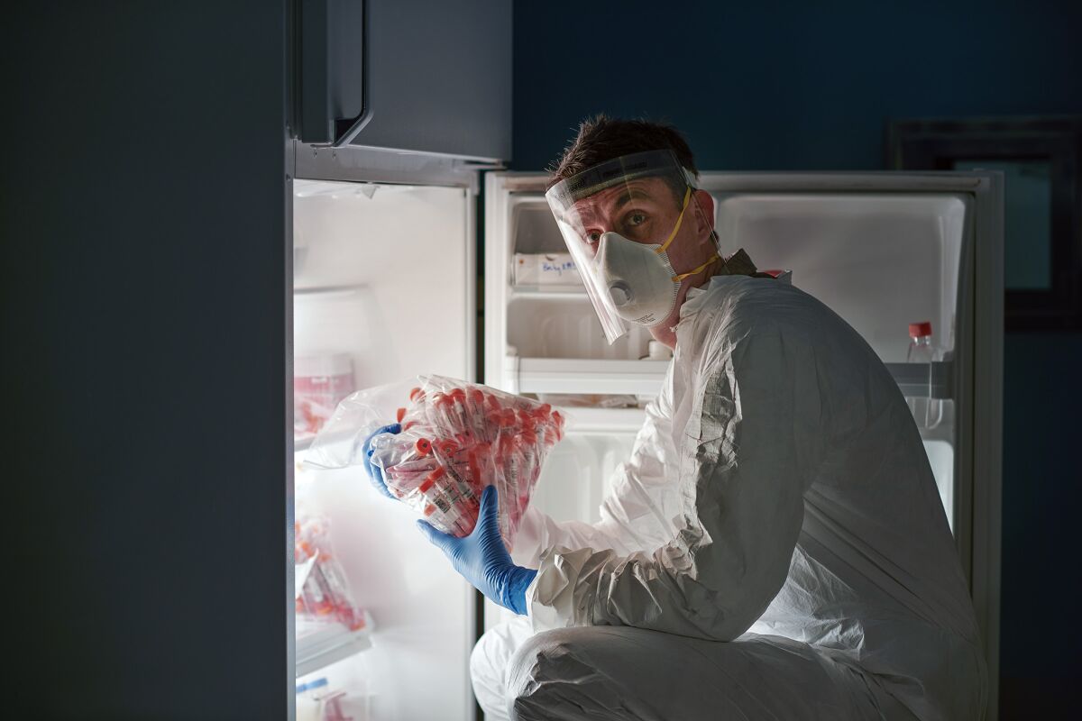 A researcher handles COVID-19 swabs prior to sequencing their viral DNA.