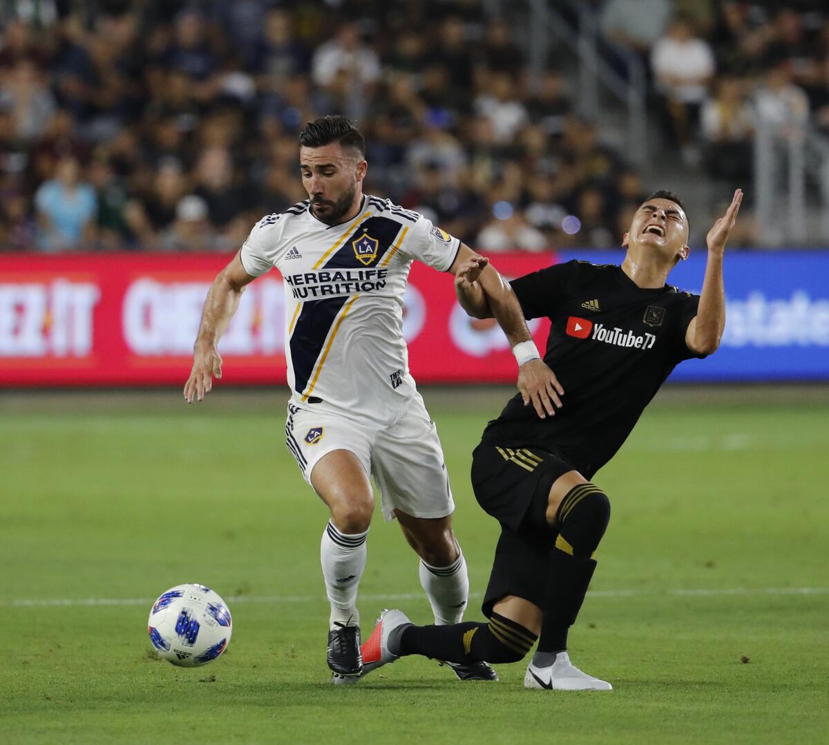 Galaxy midfielder Romain Alessandrini, left, battles LAFC midfielder Eduard Atuesta for control of the ball in the first half at the Banc of California Stadium on July 26, 2018.
