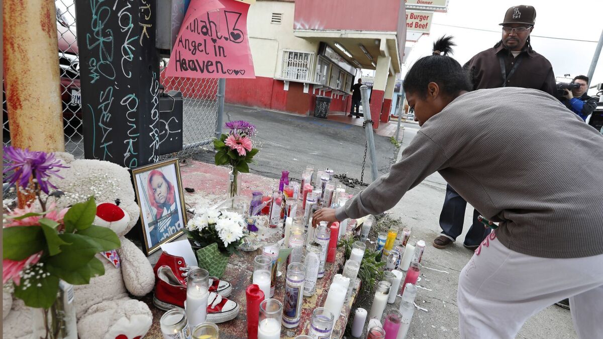 Kiara Armstrong places a candle at a memorial for slain teenager Hannah Bell.