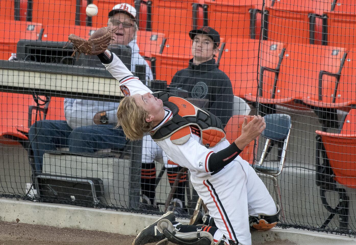 Huntington Beach's Brian Reed catches a pop up foul ball behind the plate to close out the game against La Verne Damien on Thursday, March 1.