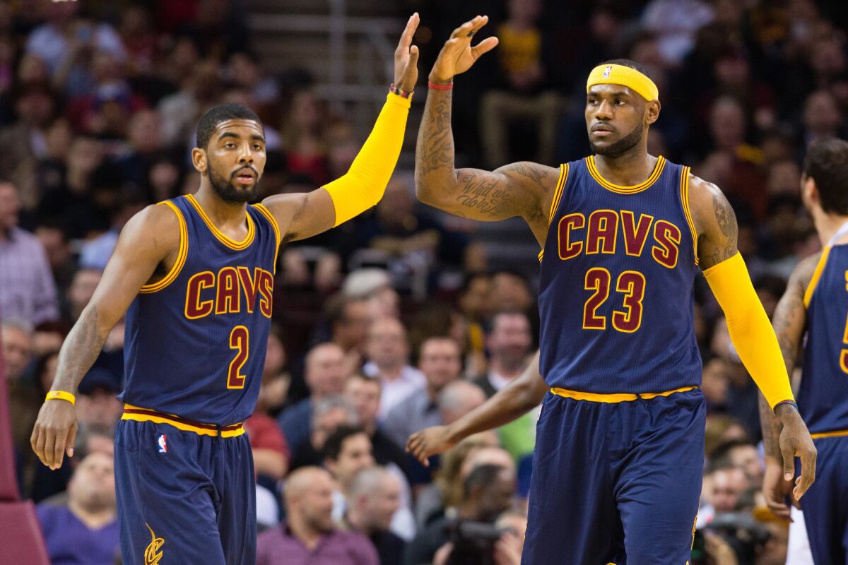 Cavaliers point guard Kyrie Irving (2) and forward LeBron James (23) celebrate after scoring against the Warriors.