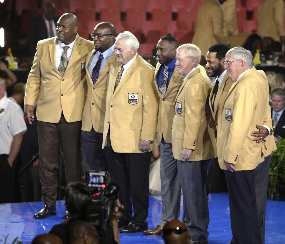 Charles Haley, left, Will Shields, Mick Tingelhoff, Tim Brown, Bill Polian, Jerome Bettis and Ron Wolf take center stage Thursday after receiving their jackets in Canton, Ohio. Class member Junior Seau was honored posthumously.