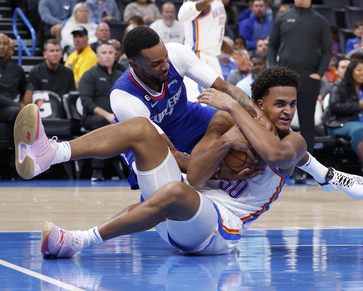 Clippers forward Norman Powell and Thunder forward Jeremiah Robinson-Earl wrestle for the ball.
