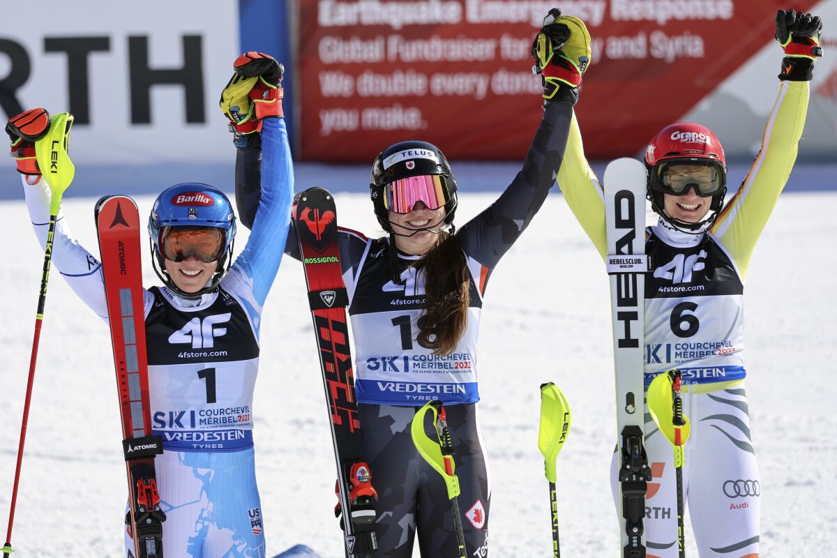 Laurence St-Germain, Mikaela Shiffrin and Lena Duerr raise their arms above their heads and smile.