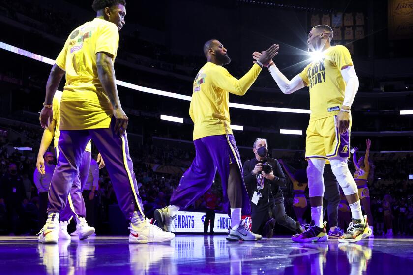 Lakers forward LeBron James slaps hands with guard Russell Westbrook during introductions before their game against the Bucks