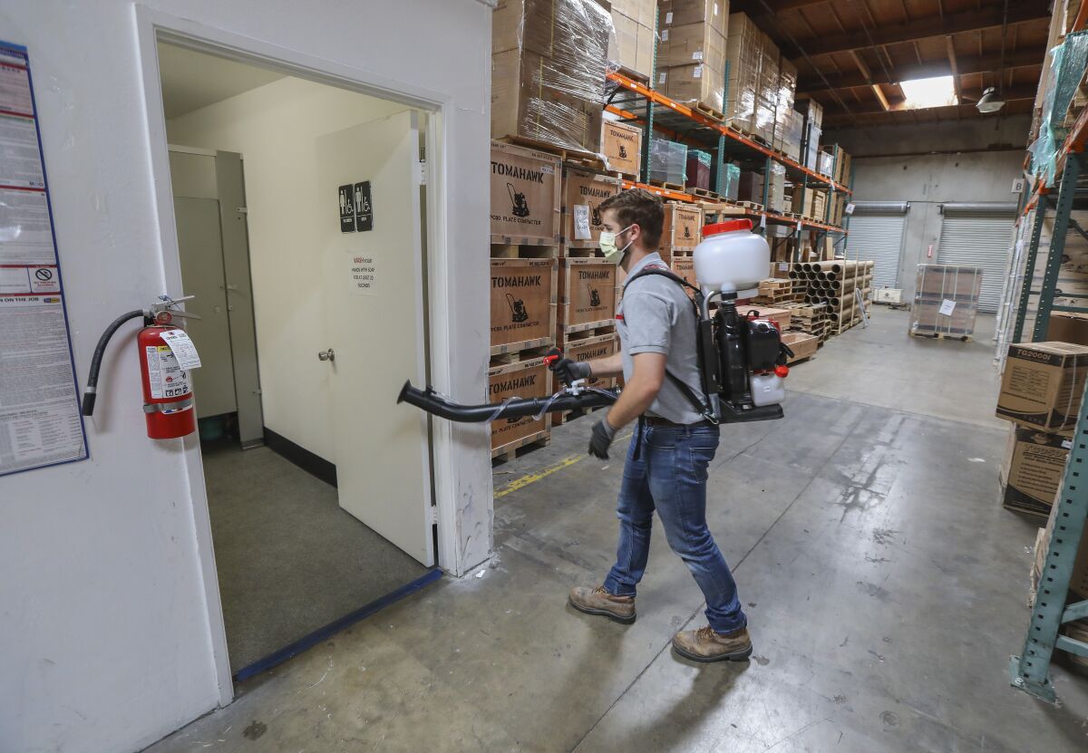 Using a sprayer called the Tomahawk Fogger, Jim Nora, national account sales manager at Tomahawk, sanitizes the bathroom at the company's warehouse in Otay Mesa area on May 8, 2020 in San Diego, California.