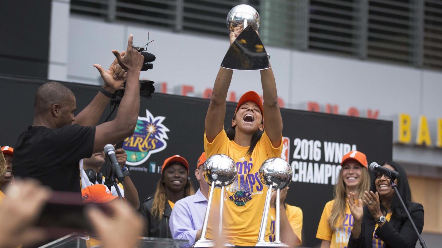 Candace Parker jubilantly hoists the WNBA trophy.