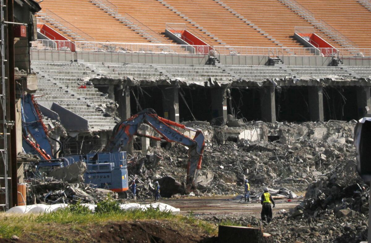 In this March 5, 2015 photo, workers dismantle Japan's old National Stadium for the renovation as Japan hosts the 2020 Tokyo Olympics.