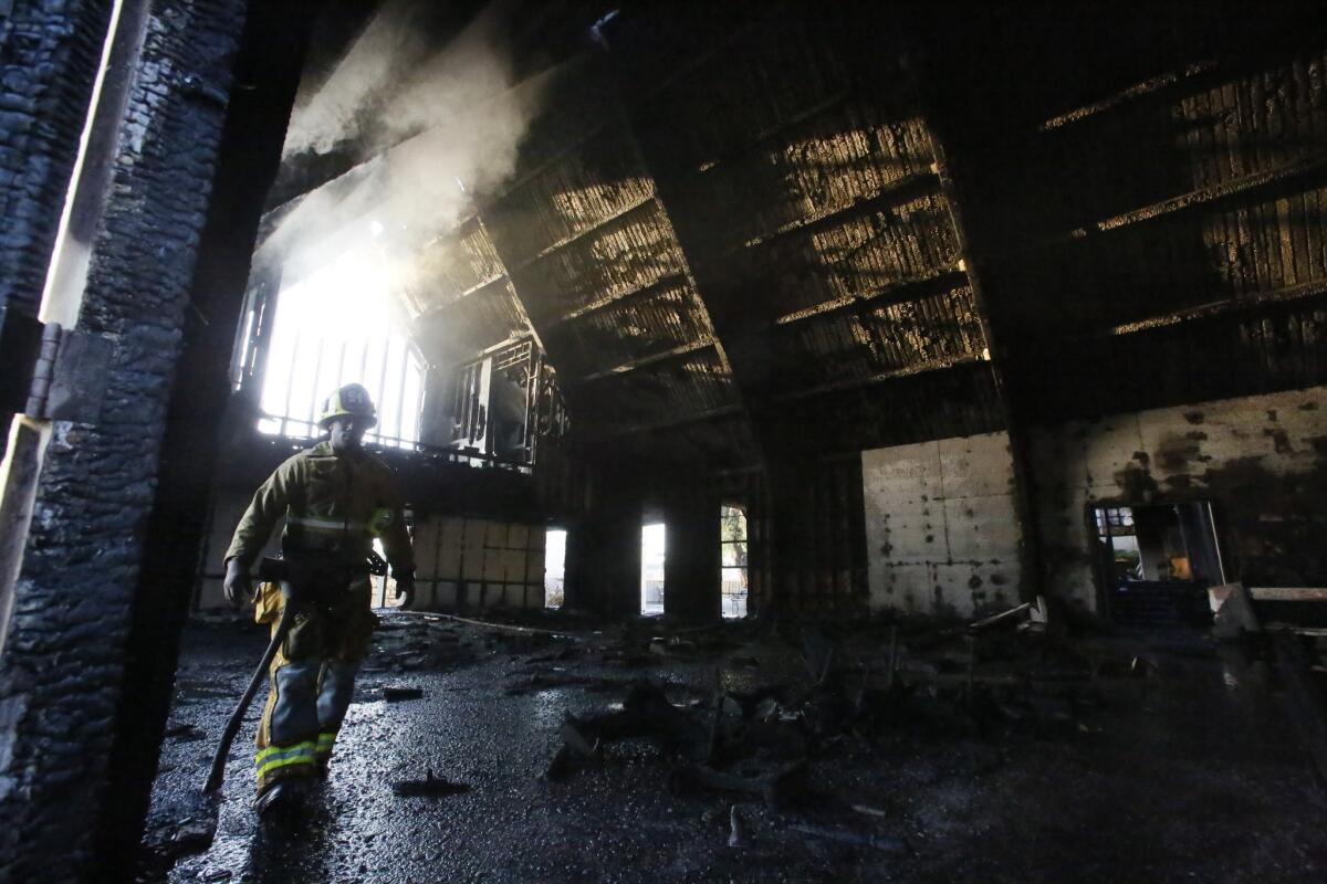 A Los Angeles firefighter walks through what's left of the Bethesda Temple Church on Crenshaw Boulevard after an early morning blaze gutted the interior.
