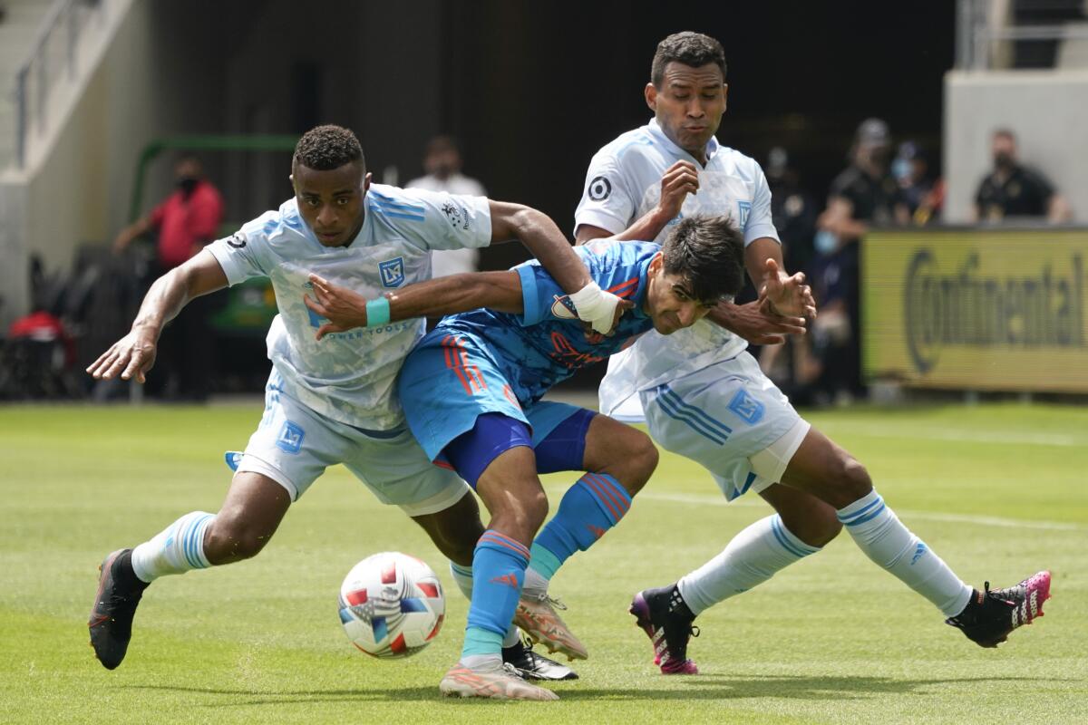 LAFC defenders Diego Palacios and Eddie Segura and NYCFC forward Andres Jasson battle the ball during a match
