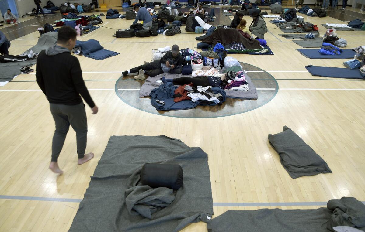 Migrants rest at a makeshift shelter in Denver.