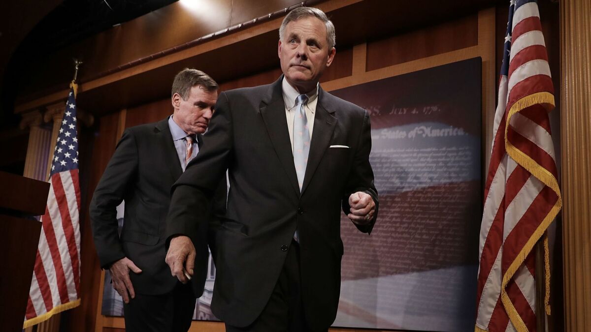 Sen. Mark Warner, left, and Sen. Richard Burr leave a news conference after discussing the Senate Intelligence Committee's upcoming work.