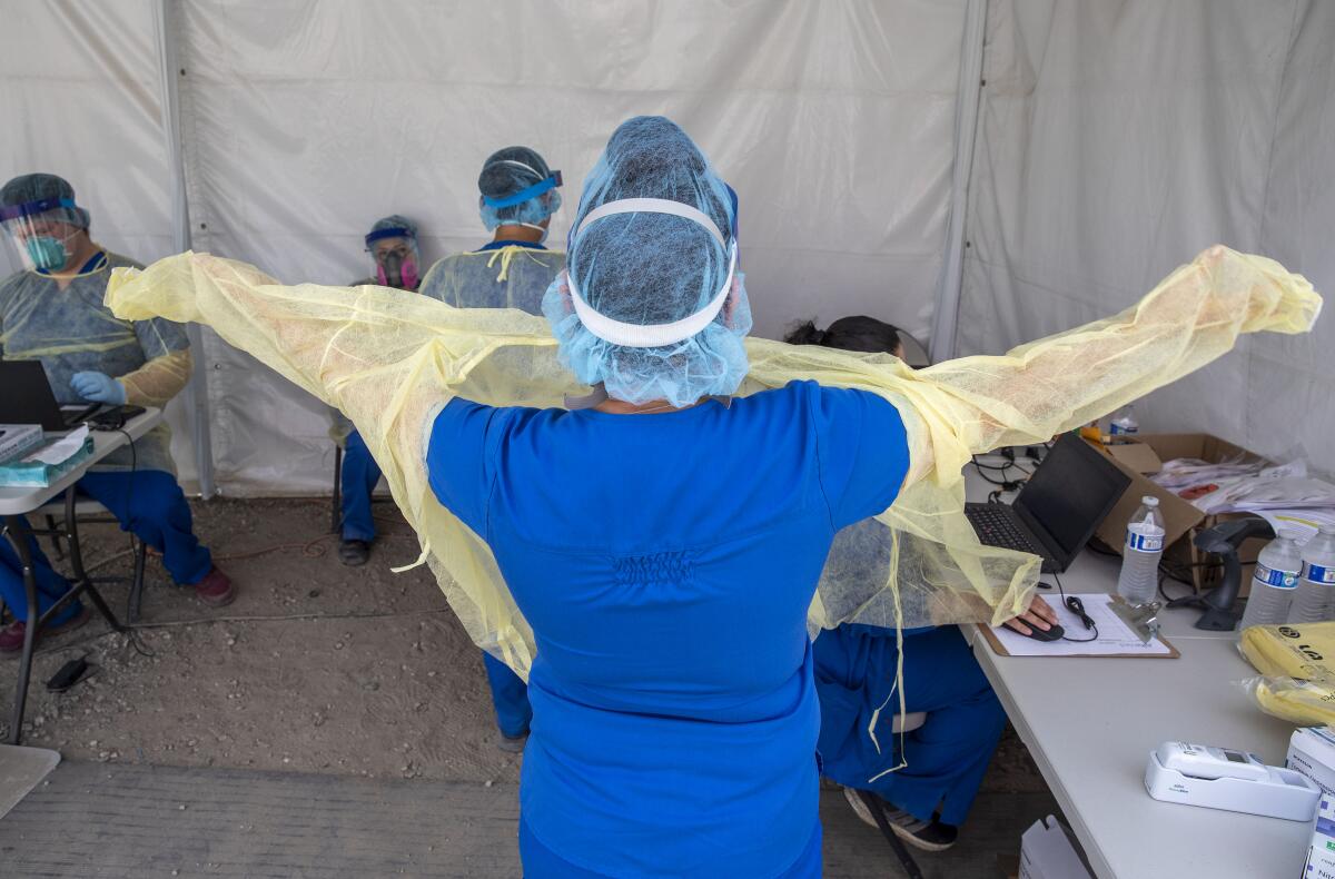 Alta Med Health Services staff put on PPE prior to COVID-19 testing in Boyle Heights