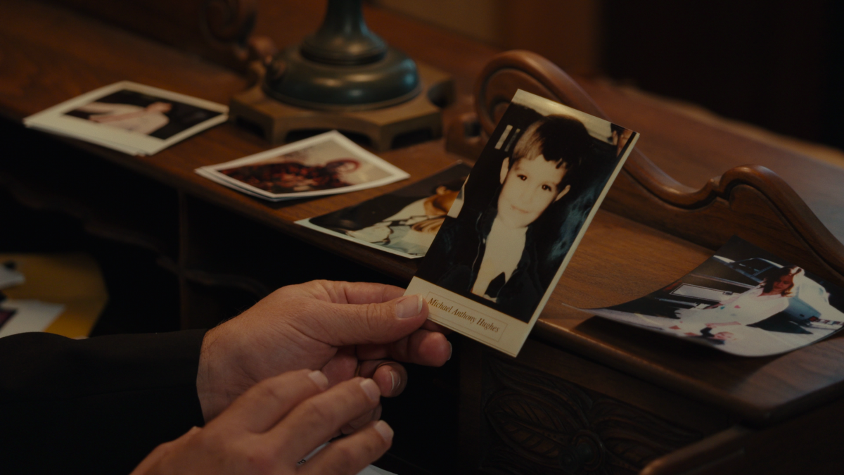 Hands holding a photo of a child in the documentary "Girl in the Picture."