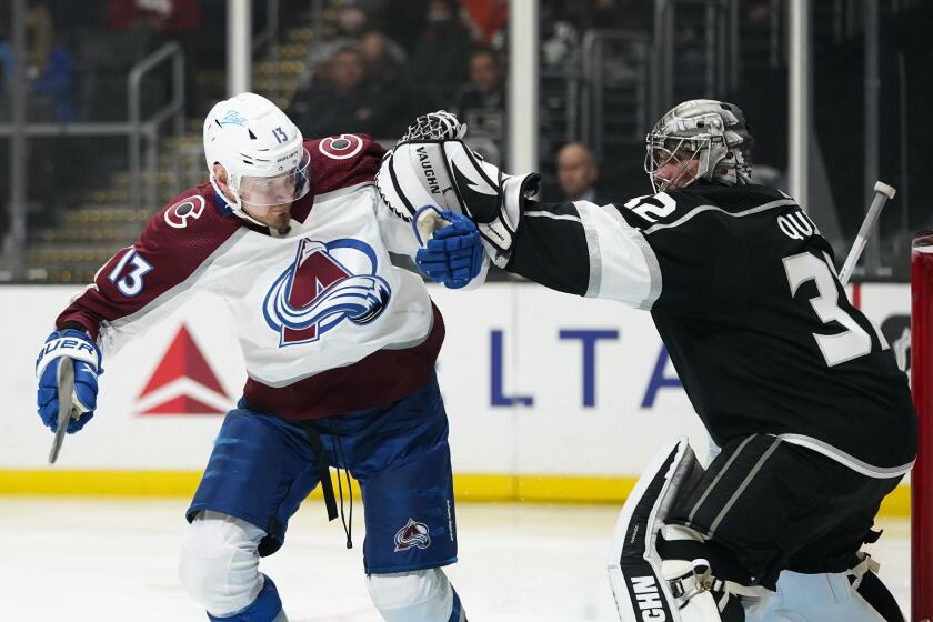 Colorado Avalanche's Valeri Nichushkin, left, is pushed by Los Angeles Kings goaltender Jonathan Quick during the third period of an NHL hockey game Tuesday, March 15, 2022, in Los Angeles. The Avalanche won 3-0. (AP Photo/Jae C. Hong)