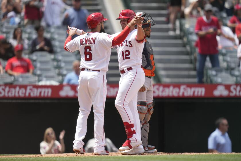 Los Angeles Angels' Anthony Rendon (6) and Hunter Renfroe (12) celebrate after they both scored off of a home run hit by Renfroe during the second inning of a baseball game against the Houston Astros in Anaheim, Calif., Wednesday, May 10, 2023. (AP Photo/Ashley Landis)