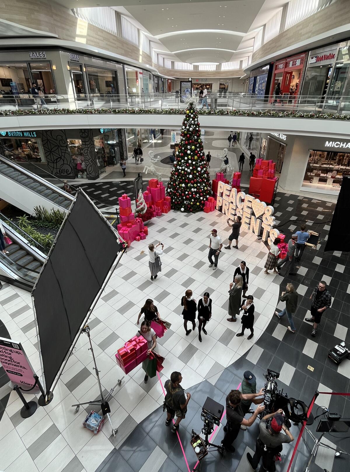 People stand near a mall Christmas tree