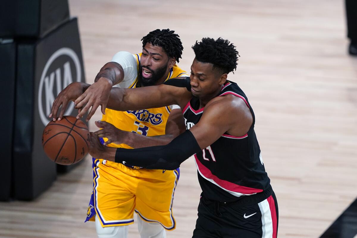 Lakers forward Anthony Davis and Portland Trail Blazers center Hassan Whiteside battle for possession.