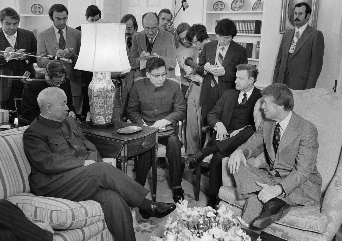 National security advisor Zbigniew Brzezinski, seated second from right, sits in as Huang Chen, chief of China's liaison office, left, meets with President Carter, right, in the Oval Office on Feb. 8, 1977.