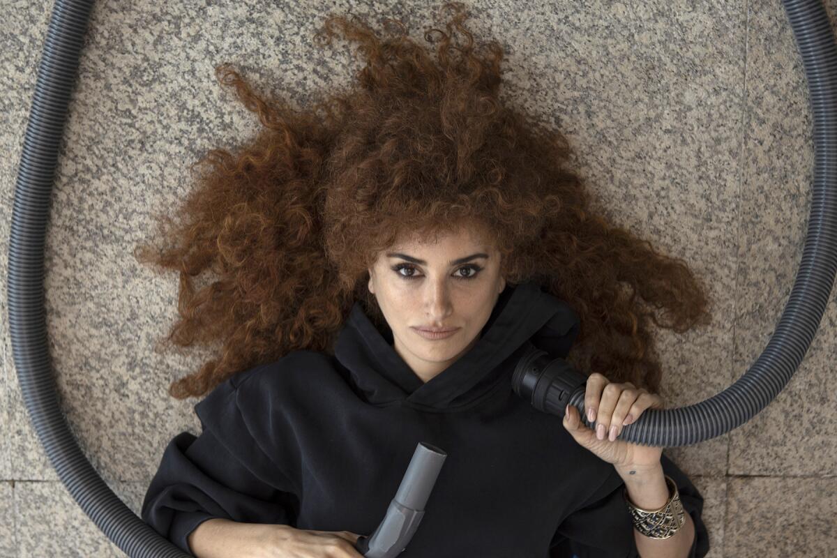 A woman lying on the floor, seen from above, with her curly brown hair spread out.