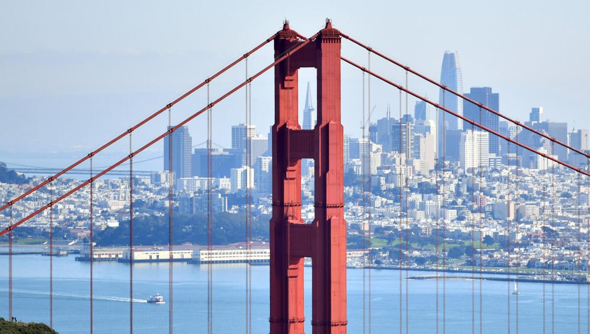 As seen from Sausalito, the TransAmerica Pyramid, once the tallest building in San Francisco, is framed in one of the towers of the Golden Gate Bridge near a taller Salesforce Tower.