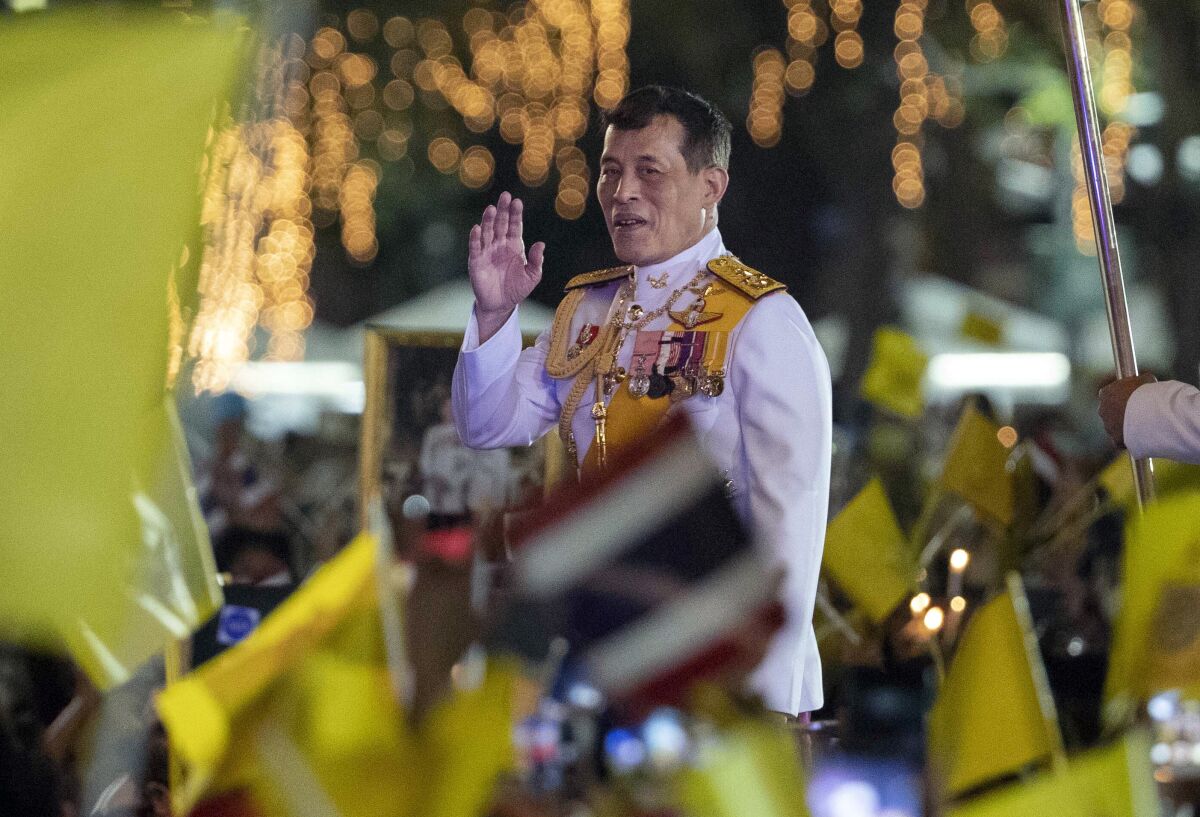 Thai King Maha Vajiralongkorn greets supporters as he walks to participate in a candle lighting ceremony to mark the anniversary of the birth of late King Bhumibol Adulyadej, at Sanam Luang ceremonial ground in Bangkok, Thailand, Saturday, Dec. 5, 2020. Thousands of yellow-clad supporters greeted Thailand's king in Bangkok on Saturday as he led a birthday commemoration for his revered late father, the latest in a series of public appearances at a time of unprecedented challenge to the monarchy from student-led protestors.(AP Photo/Gemunu Amarasinghe)