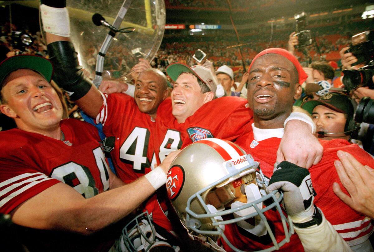 San Francisco 49ers quarterback Steve Young (8) celebrates with teammates in 1995.