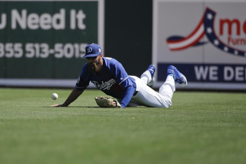 Dodgers outfielder Scott Van Slyke misses a ball hit by Reds outfielder Jay Bruce during a spring training game on Mar. 27.
