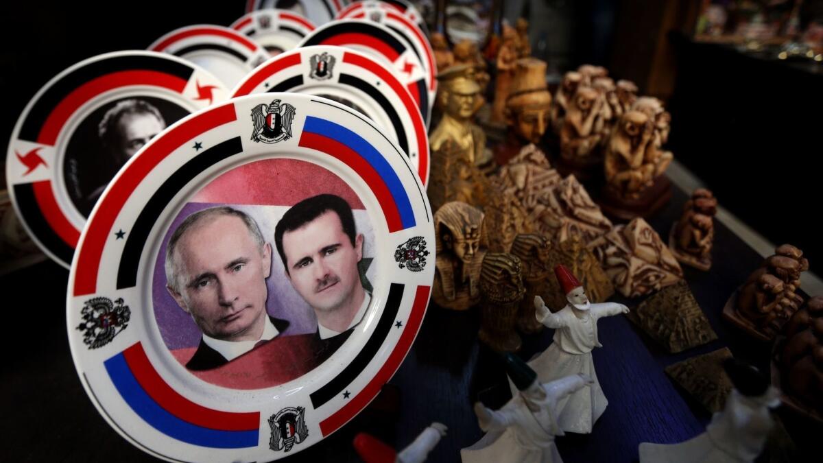 Porcelain plates bearing portraits of Bashar Assad and Vladimir Putin are displayed at a shop in Damascus in 2016.