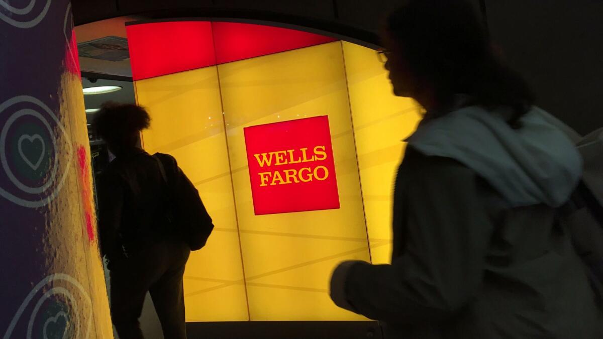 Commuters walk by a Wells Fargo ATM location at New York's Penn Station on Oct. 13, 2016.