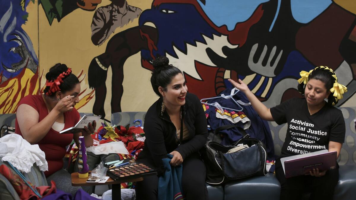 Mariela Hernandez, left, Angela Vera and Jennifer Lima of Ballet Folklórico de UCI get ready for a performance on campus.