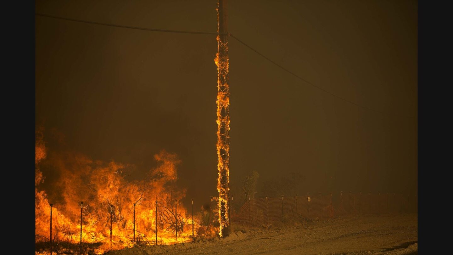 A power pole burns as the Blue Cut fire burns out of control on both sides of Highway 138 in Summit Valley, California.